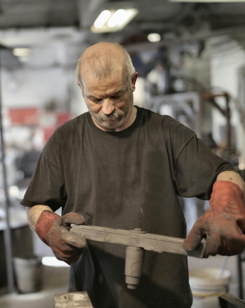 Focused senior fitter assembling detail in workshop